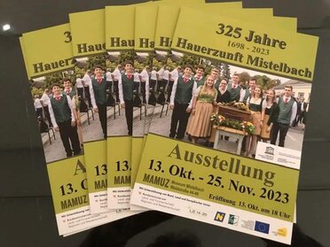 Einladungsflyer zur Eröffnung der Ausstellung "325 Jahre Hauerzunft Mistelbach". Ein grüner Flyer mit der Aufschrift "325 Jahre Hauerzunft Mistelbach" und dem Datum der Ausstellung.
