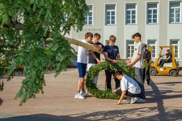 Jugendliche bereiten den Maibaum fürs Aufstellen vor