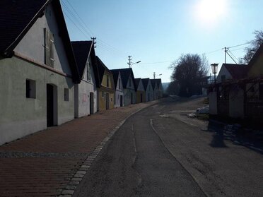 Kellergasse Falkenstein bei Sonnenaufgang, an der linken Bildseite reihen sich die Presshäuser aneinander, mittig die Straße