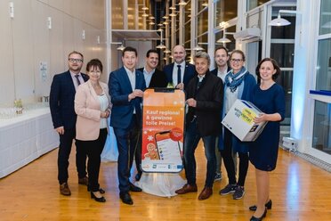 Gruppenfoto zur Bewerbung der Kauf Regional App in Mistelbach. Am Bild zu sehen die Vertreter der Projektträger Städte mit einem Werbesujet zur Cities-App